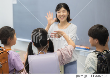 小学校の教室でさようならをする先生と生徒 小学校の教室でさようならをする先生と生徒 115607598