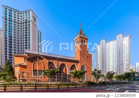 The beautiful Catholic church, designed with modern architecture and constructed from orange brick, reflects the stunning evening light. 115608059