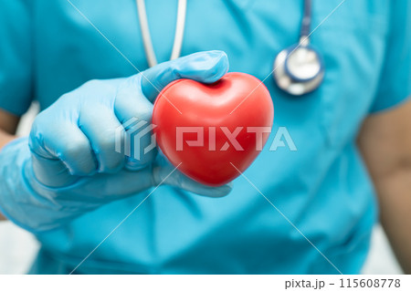 Doctor holding a red heart in hospital ward, healthy strong medical concept. 115608778