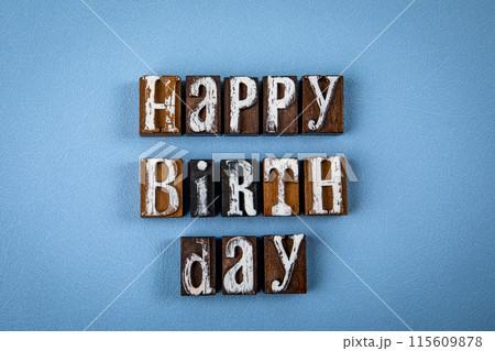 HAPPY BIRTH DAY. Wooden alphabet letter blocks on blue textured background 115609878