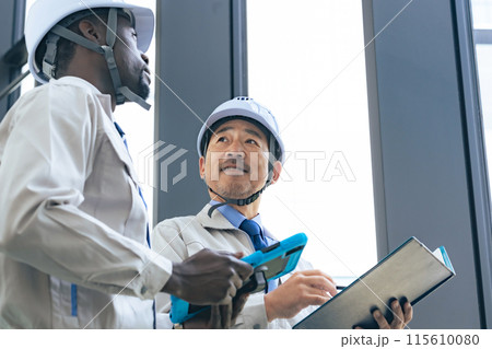 建物の中で会話する多国籍エンジニアのグループ 115610080