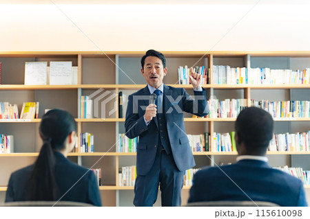 ロビーでスピーチするミドル男性 ロビーでスピーチするミドル男性 115610098