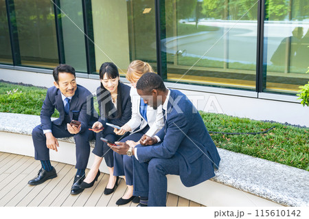 スマホの翻訳アプリを使って会話する多国籍ビジネスパーソンのグループ スマホの翻訳アプリを使って会話する多国籍ビジネスパーソンのグループ 115610142