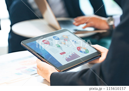 タブレットを持ってミーティングに参加するビジネスパーソン タブレットを持ってミーティングに参加するビジネスパーソン 115610157