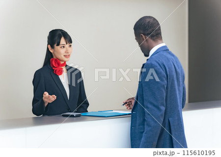 外国人訪問者を接客する女性スタッフ 115610195