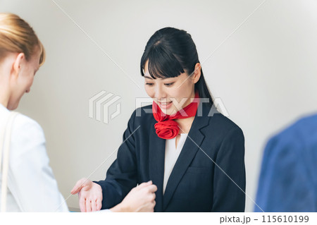 外国人訪問者を接客する女性スタッフ 115610199
