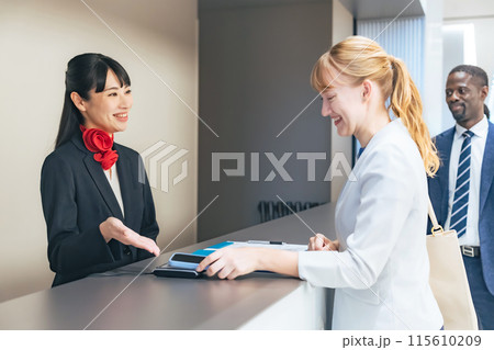 カウンターでスマホタッチ決済する外国人女性 115610209