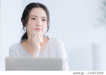 パソコン作業をする若い女性　考える悩むの頬杖のポーズ 115611870