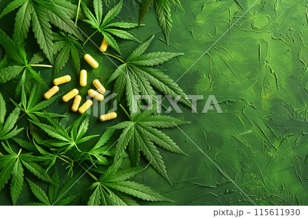 Cannabis Leaves and Capsules on Green Textured Background 115611930