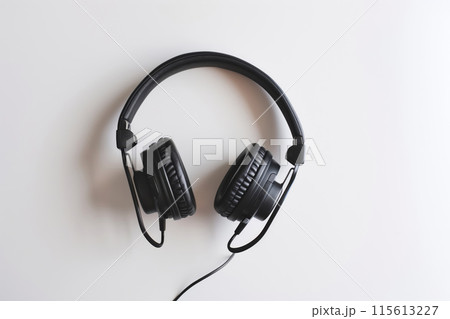 Over-the-ear black headphones with cable on a plain white background, minimalist audio concept 115613227