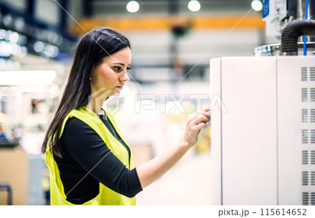 Warehouse employee in warehouse. Female worker in reflective clothing in modern industrial factory, heavy industry, manufactrury. 115614652
