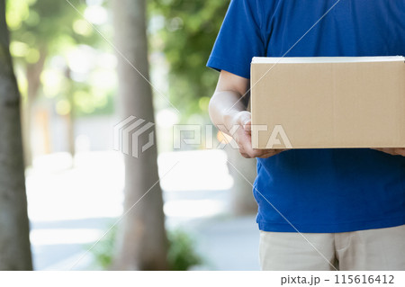 荷物を持つ配達員の男性 115616412