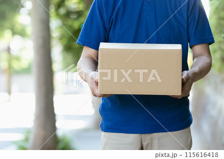 荷物を持つ配達員の男性 115616418