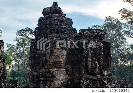 The bayon temple smiling stone faces showing on a sunny day in angkor thom, siem reap, cambodia The bayon temple smiling stone faces showing on a sunny day in angkor thom, siem reap, cambodia 115616543