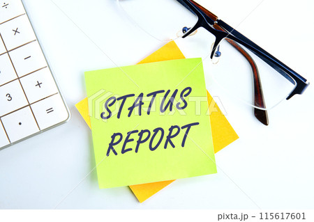 Inscription Status Report text the inscription on the sticker on a light background next to the clock and calculator Inscription Status Report text the inscription on the sticker on a light background next to the clock and calculator 115617601