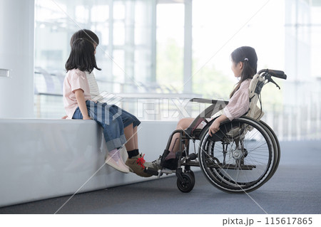 車椅子にのる小学生と目線を一緒に話す友達 心のバリアフリーのイメージ 車椅子にのる小学生と目線を一緒に話す友達 心のバリアフリーのイメージ 115617865