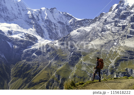 Sporty woman standing in front of snow mountains and enjoying view of Switzerland nature. Wanderlust, sport, beauty in nature. 115618222