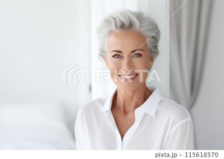 Portrait of beautiful happy smiling mature woman with gray hair in white living room at home 115618570