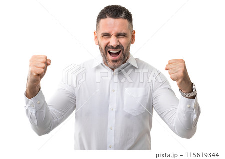 A man wearing a white shirt is standing with his fists raised in a defensive position. He appears ready for confrontation or defense, displaying a strong and assertive posture. A man wearing a white shirt is standing with his fists raised in a defensive position. He appears ready for confrontation or defense, displaying a strong and assertive posture. 115619344