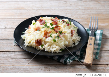 Slovak potato dumplings halusky with steamed sauerkraut and bacon on wooden table Slovak potato dumplings halusky with steamed sauerkraut and bacon on wooden table 115620184