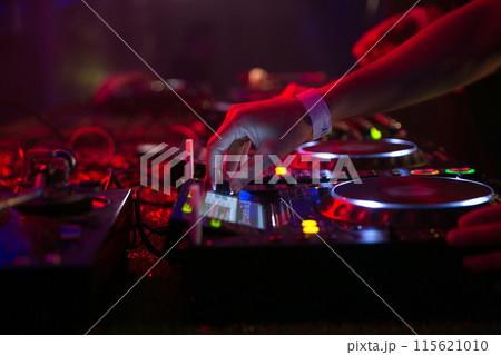Close up view of a dj's hands playing the mixer while performing. High quality photo 115621010