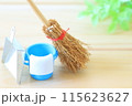 ヒノキの板の上にあるミニチュアの箒とバケツとチリトリ 115623627