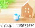 木の板の上にあるミニチュアの家とバケツ 115623630
