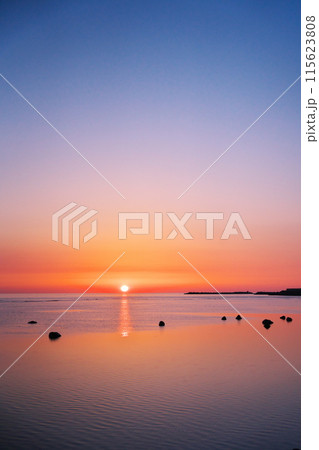早春の日本最北端から朝凪の海に昇る太陽を臨む 115623808
