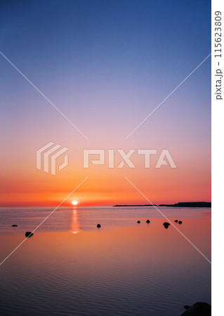 早春の日本最北端から朝凪の海に昇る太陽を臨む 115623809