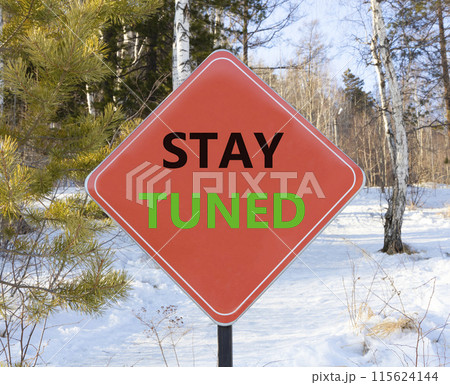 Stay tuned symbol. Concept words Stay tuned on beautiful red road sign. Beautiful forest snow blue sky background. Business, support, motivation, psychological and stay tuned concept. Copy space. Stay tuned symbol. Concept words Stay tuned on beautiful red road sign. Beautiful forest snow blue sky background. Business, support, motivation, psychological and stay tuned concept. Copy space. 115624144