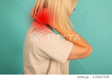 A woman with a red neck is wearing a white shirt. She is holding her neck and she is in pain 115625330