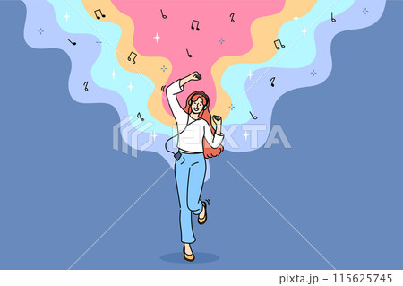 Teenage woman listens to music on headphones and dances rhythmically with hands, and uses phone 115625745