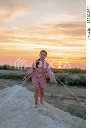 Girl 10-13 years old at sunset on a high mountain Girl 10-13 years old at sunset on a high mountain 115628444