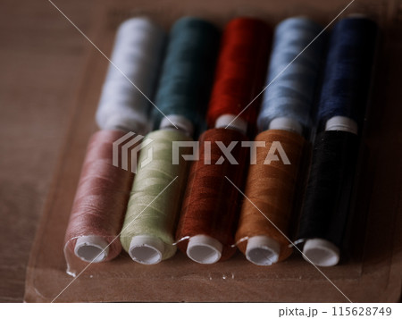 Multicolored sewing threads on paper bobbins and spools in blister packs. Threads for needlework, hobbies and recreation. Necessary item for every family. Materials for clothing repair and embroidery Multicolored sewing threads on paper bobbins and spools in blister packs. Threads for needlework, hobbies and recreation. Necessary item for every family. Materials for clothing repair and embroidery 115628749