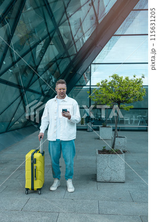 Young Caucasian male passenger in stylish casual clothes using smartphone and laptop keyboard, sit has training online meeting on laptop computer in airline lounge wait transit international airport 115631205