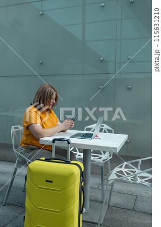 Caucasian male tourist in casual clothes standing with a yellow suitcase near the airport. Vacations, advertising taxi service. Caucasian male tourist in casual clothes standing with a yellow suitcase near the airport. Vacations, advertising taxi service. 115631210