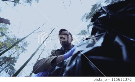 Male detective peers into a body bag, his expression one of shock at the gruesome sight Male detective peers into a body bag, his expression one of shock at the gruesome sight 115631376