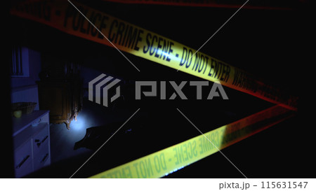 Dead victim lying on the floor in a dark office, crime scene secured by police tape 115631547