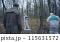 Skilled investigators visiting a crime scene outdoors, experts collecting evidence 115631572