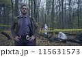 Professional police detective standing near a crime scene with hands akimbo 115631573