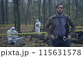 Concerned police detective looking at the camera, experts working at a crime scene 115631578