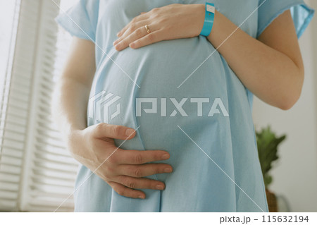 Close up photo of pregnant woman touching her belly and caring about her unborn child 115632194