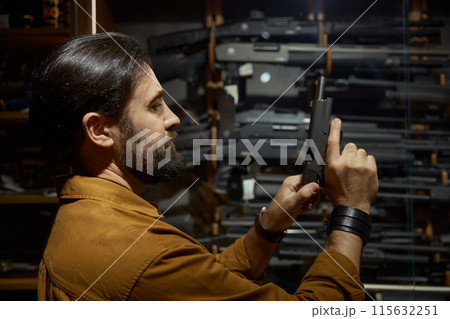 Male retailer or client checking handgun portrait with selective focus 115632251
