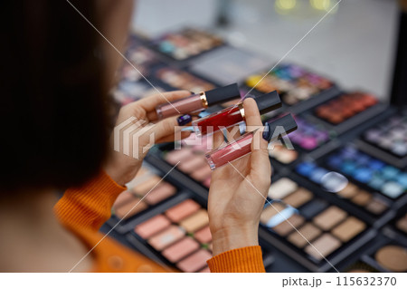Attractive woman choosing lipstick in cosmetics store 115632370