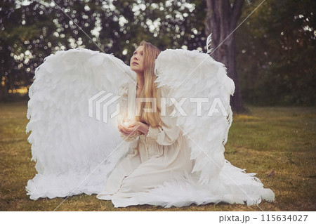 Girl angel with a candle in the evening forest Girl angel with a candle in the evening forest 115634027