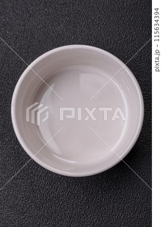 Beautiful empty white ceramic gravy boat on a concrete background 115634394