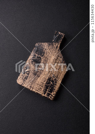 Empty wooden cutting board on dark textured concrete background 115634430