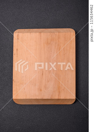 Empty wooden cutting board on dark textured concrete background Empty wooden cutting board on dark textured concrete background 115634462