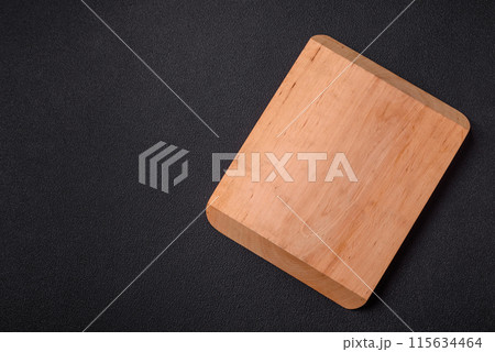 Empty wooden cutting board on dark textured concrete background 115634464