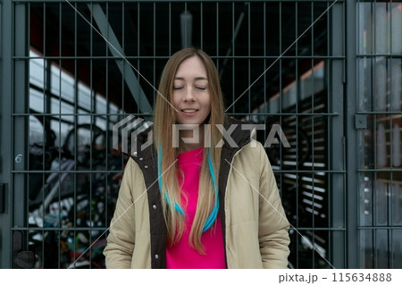 Woman Standing in Front of Metal Gate Woman Standing in Front of Metal Gate 115634888